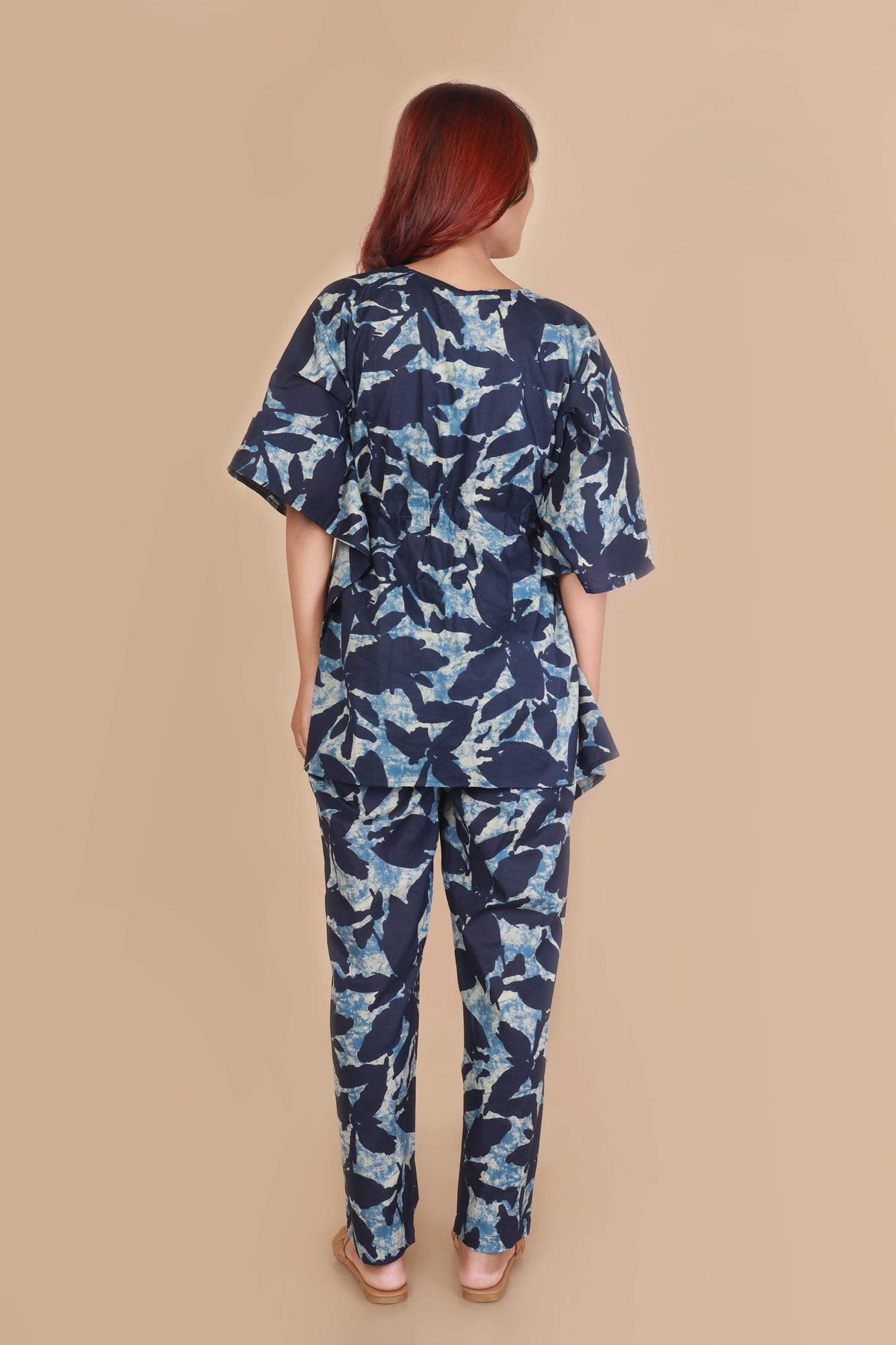 Woman wearing a blue floral outfit on a beige background
