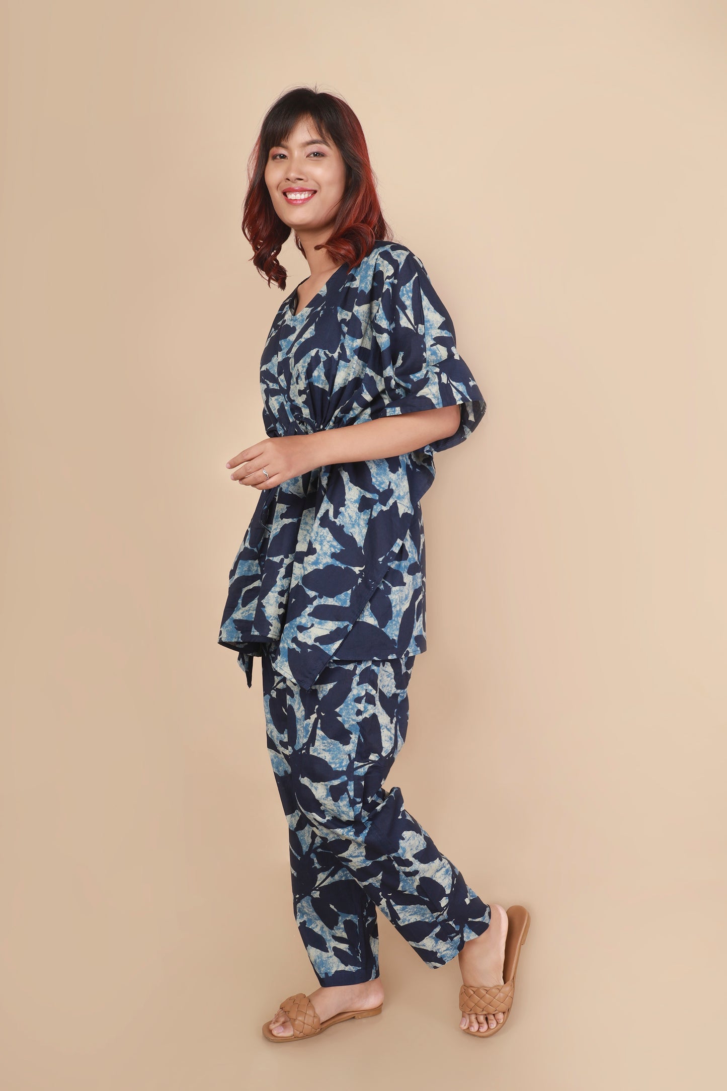 Woman wearing a blue floral outfit on a beige background