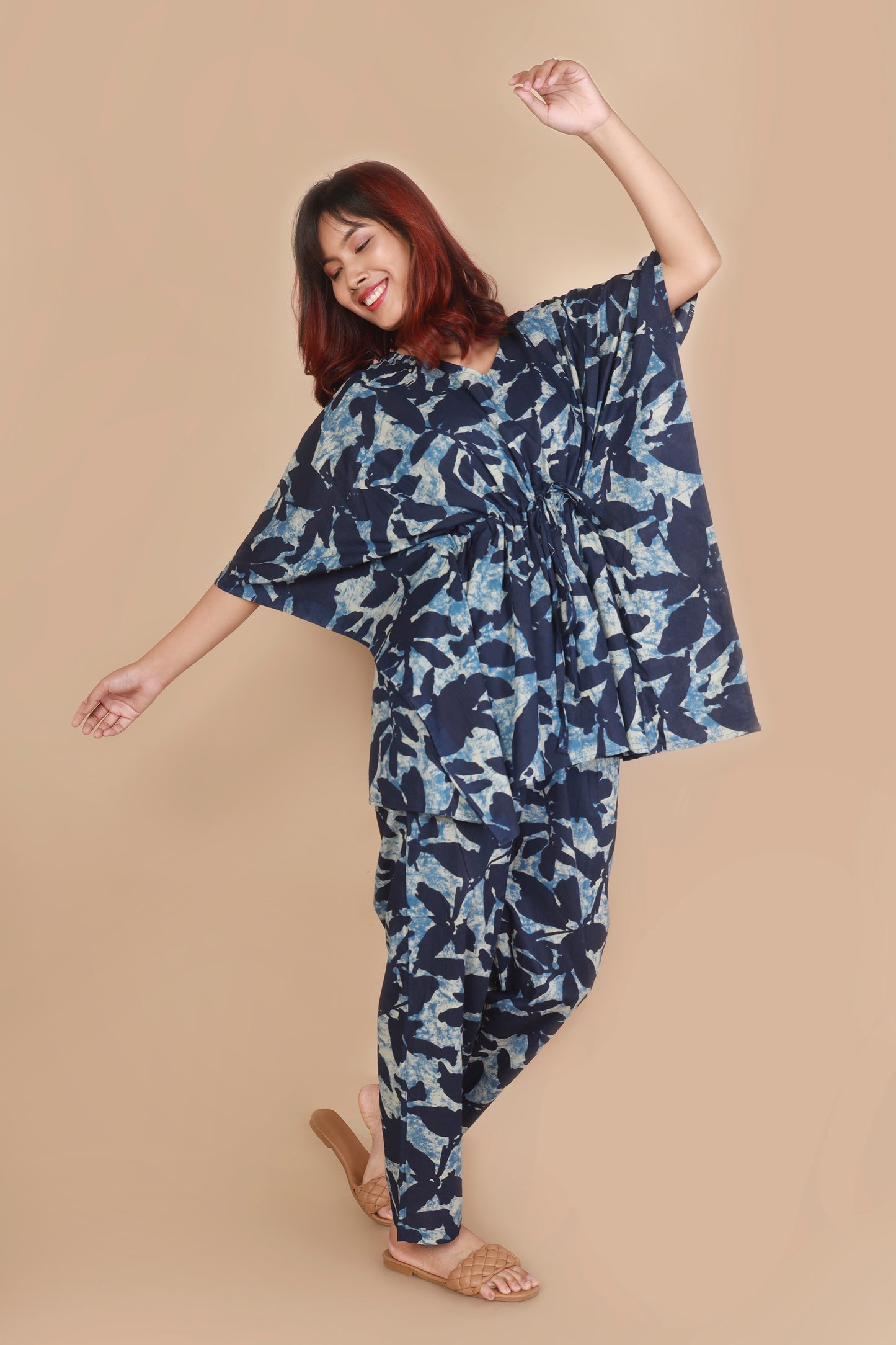 Woman wearing a blue floral dress against a beige background