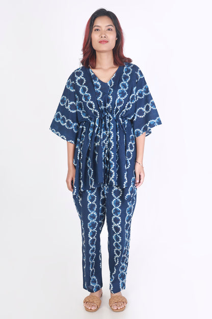 Woman wearing a blue patterned jumpsuit on a white background