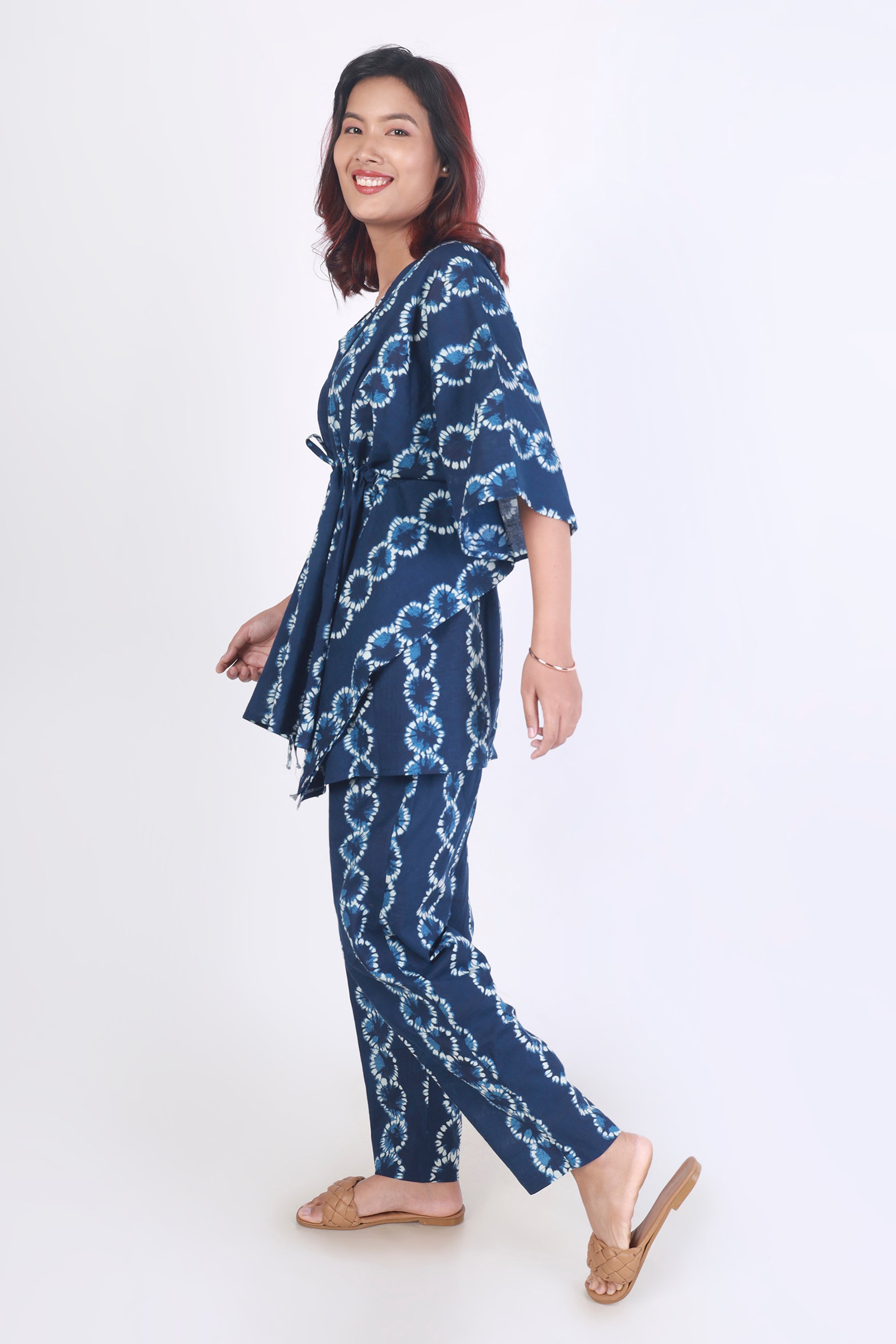 Woman wearing a blue patterned outfit on a white background