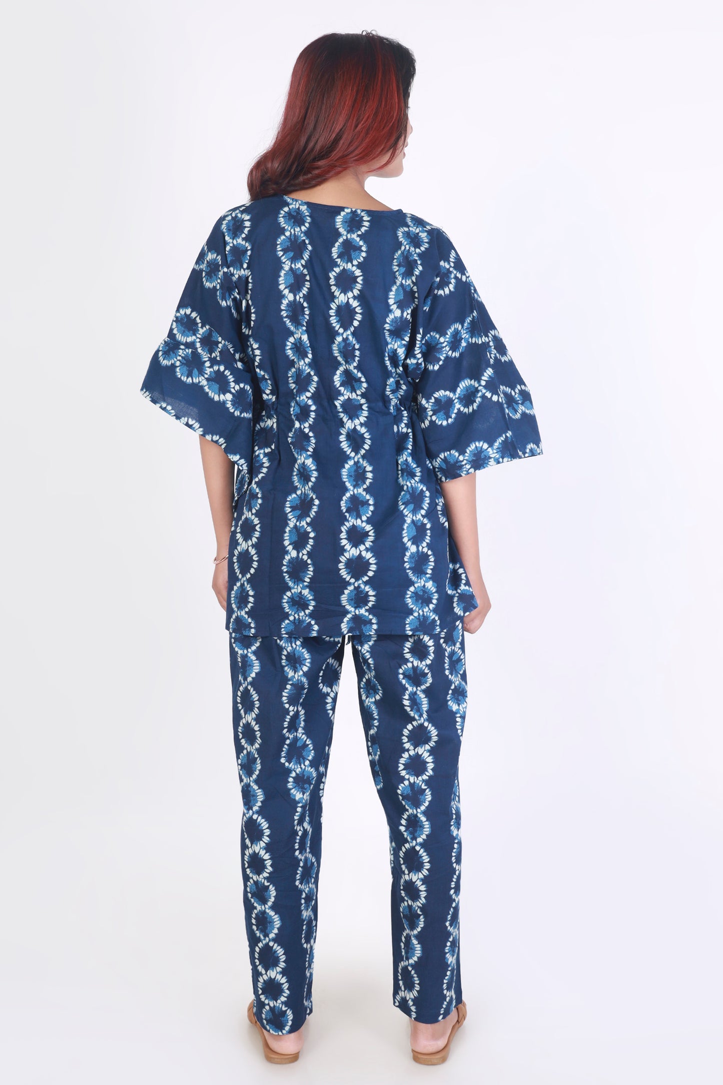 Woman wearing a blue and white patterned outfit on a white background