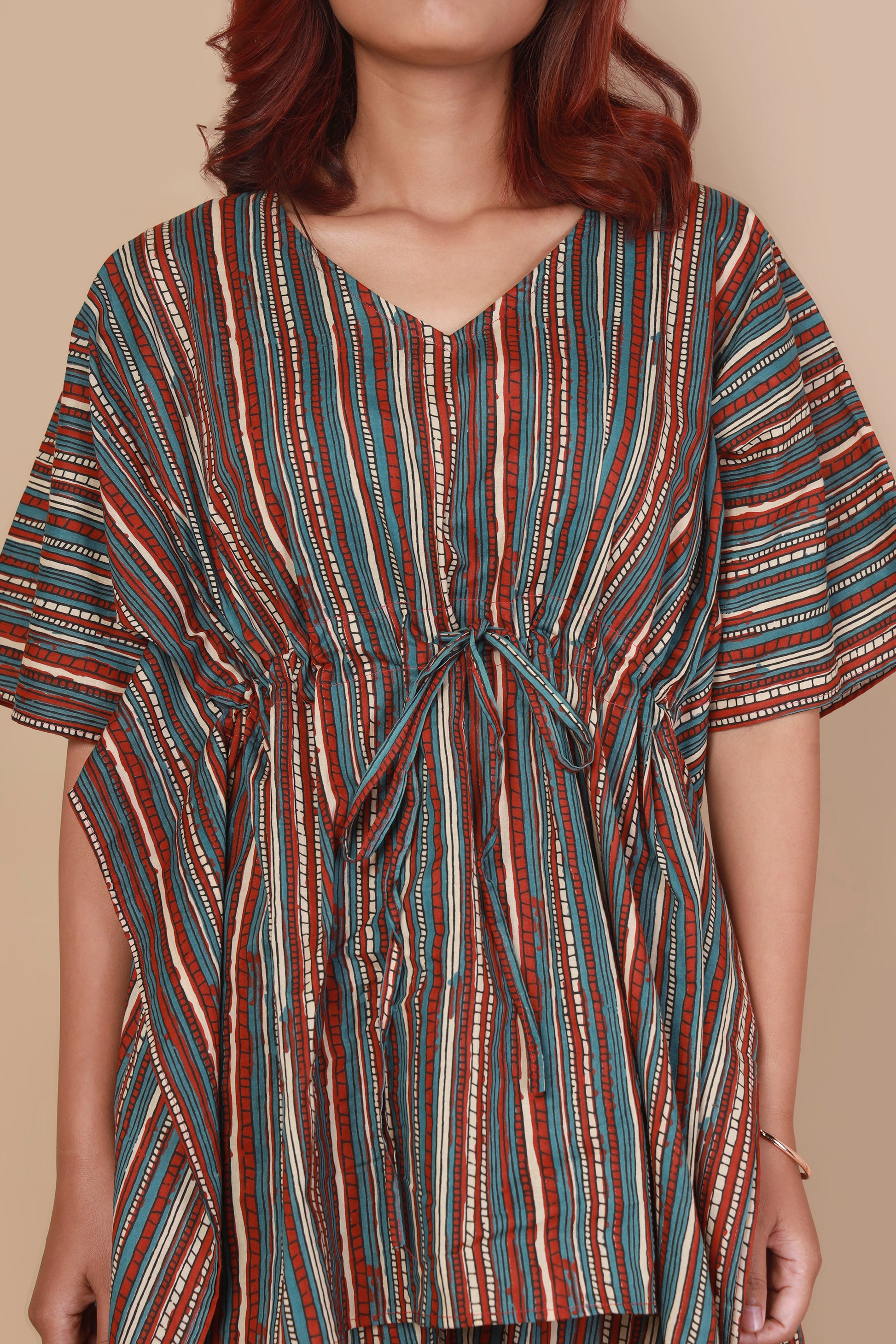 Multicolored striped dress worn by a person on a beige background