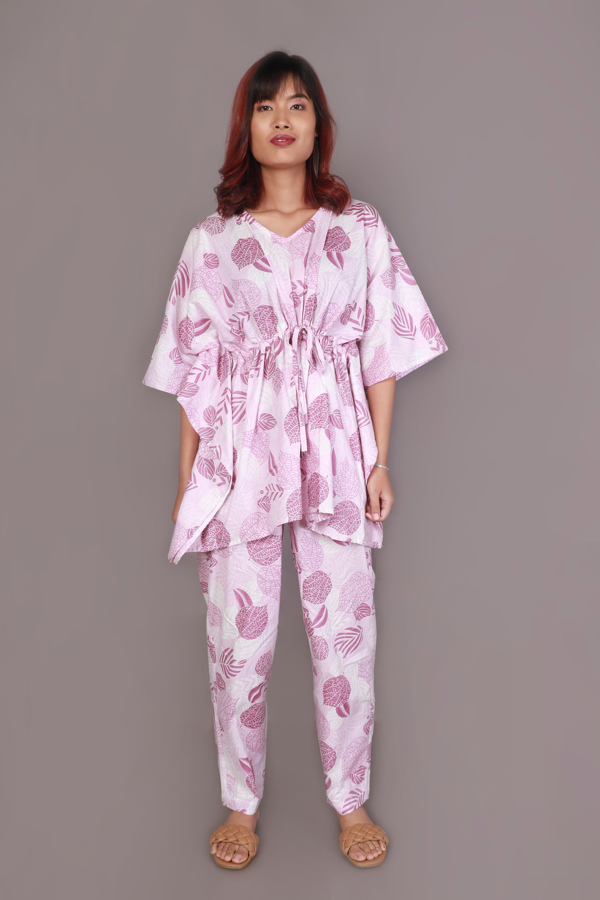 Woman wearing a pink and white patterned outfit on a gray background