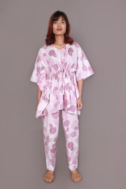 Woman wearing a pink and white patterned outfit on a gray background