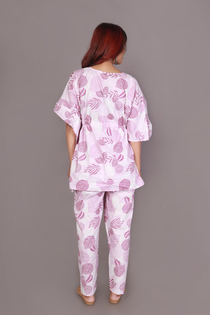 Person wearing a pink and white patterned outfit against a gray background