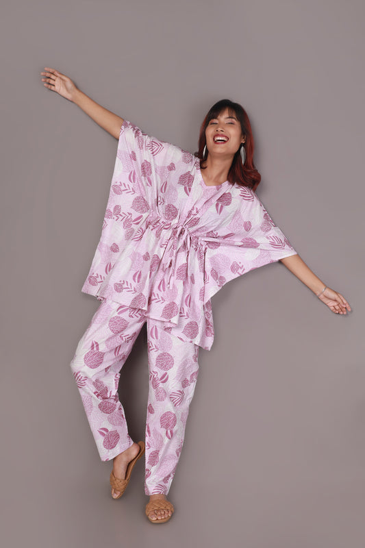 Woman wearing a pink and white patterned outfit against a gray background