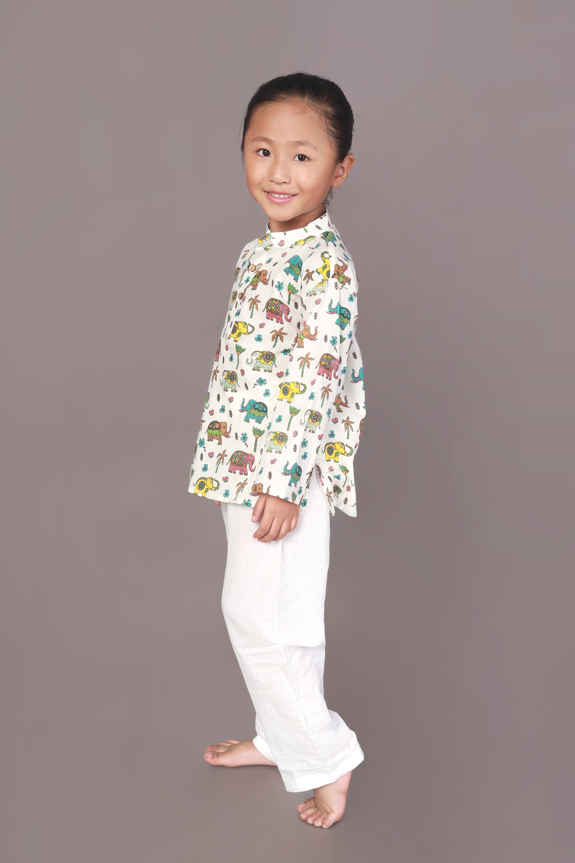 Child wearing a colorful elephant animal patterned Kurta and white pants 