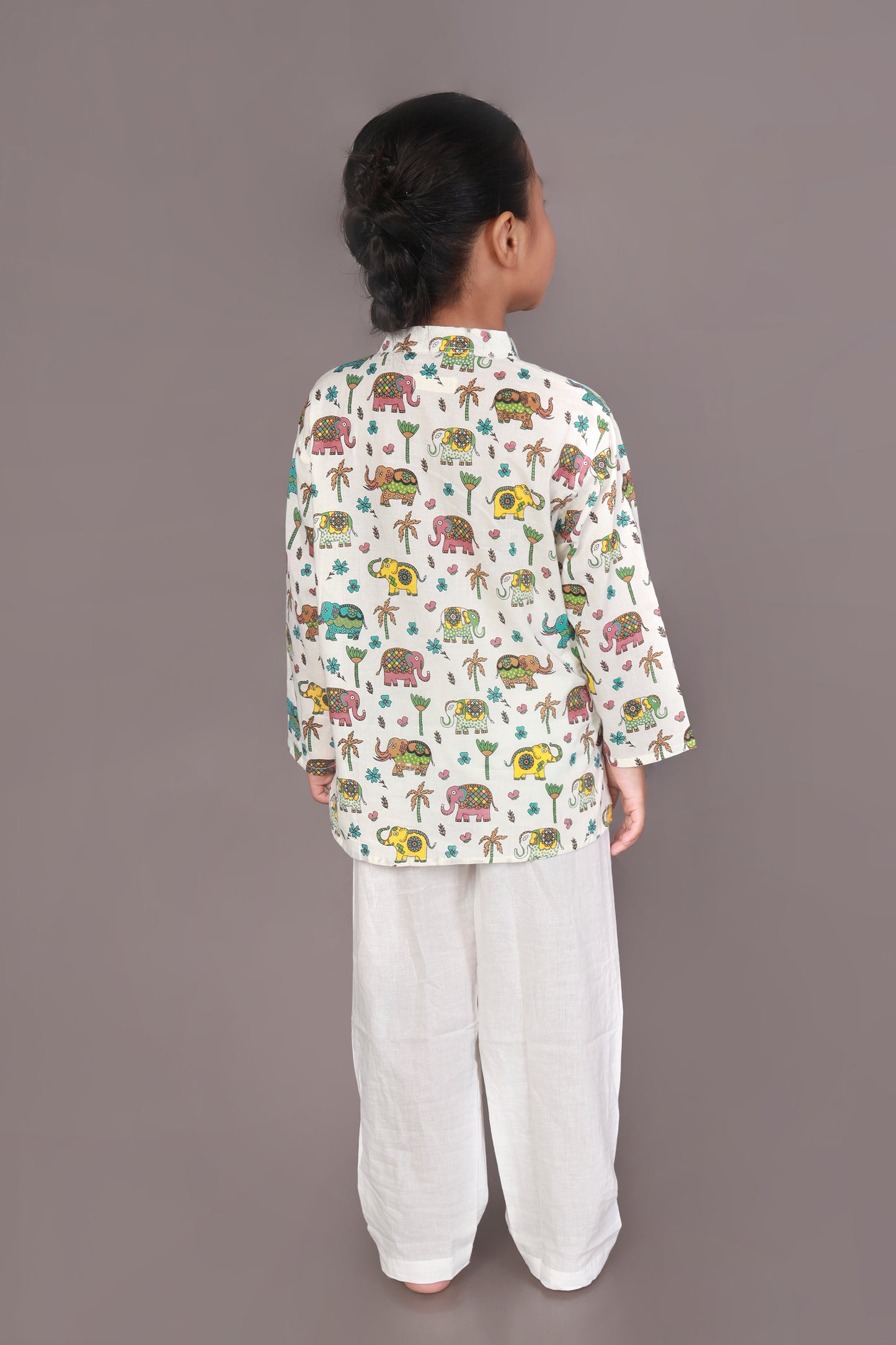 Child wearing a colorful elephant animal patterned Kurta and white pants 