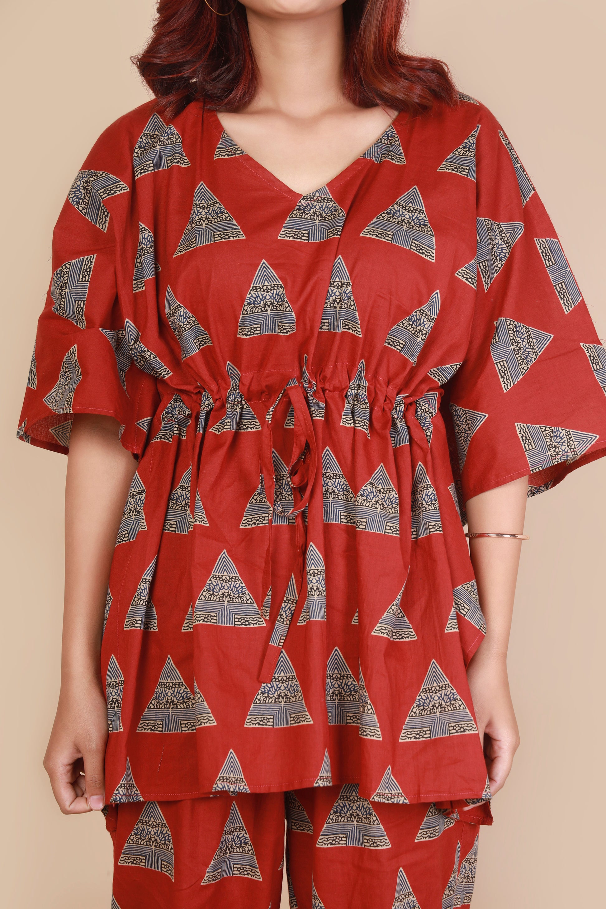 Red patterned outfit worn by a person on a beige background