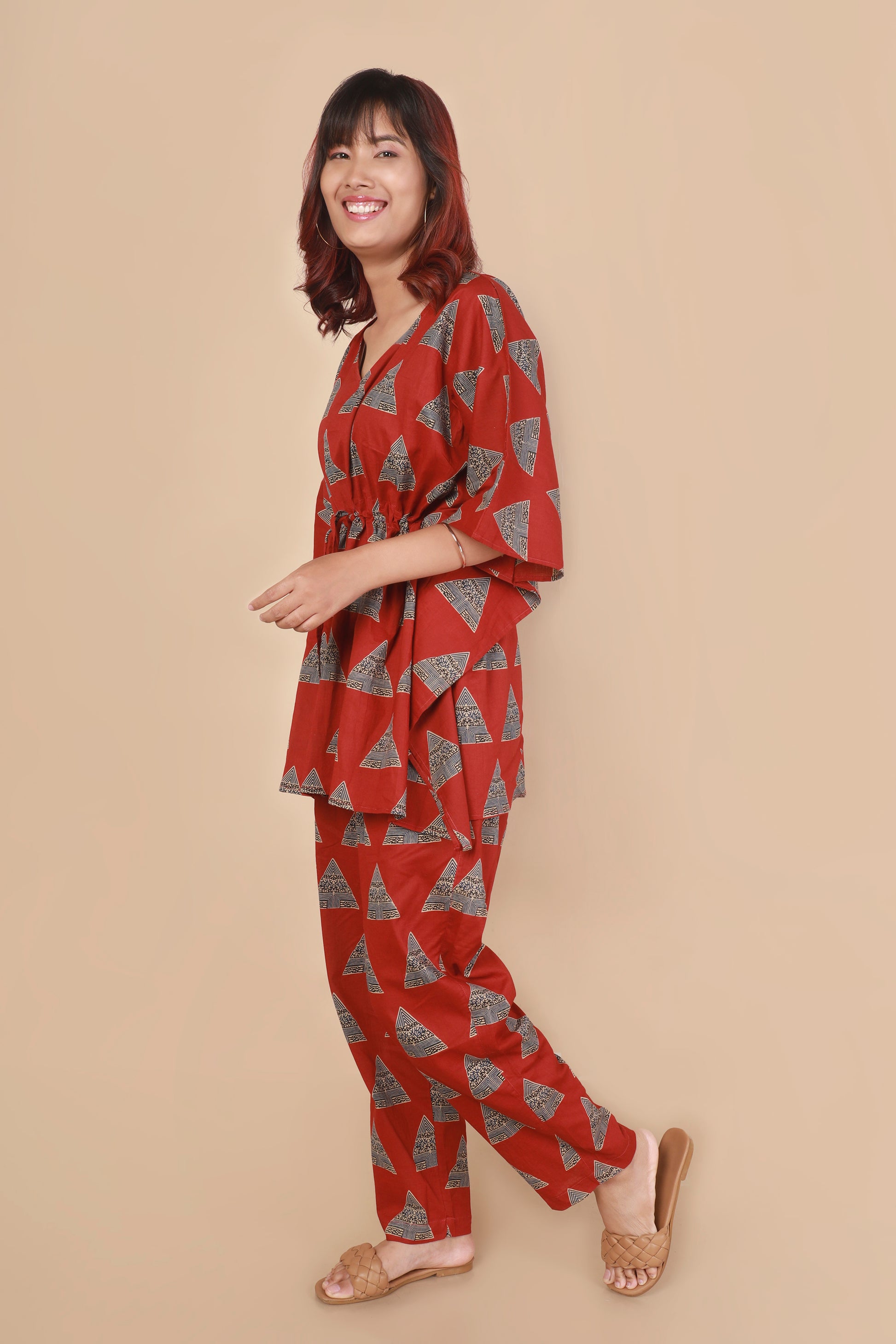 Woman wearing a red patterned outfit on a beige background