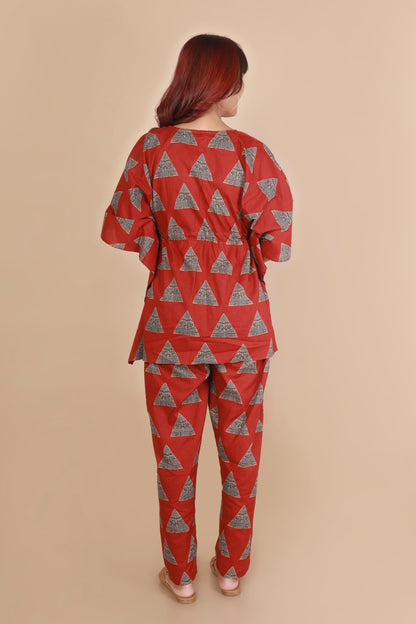 Person wearing a red and gray triangle-patterned outfit on a beige background