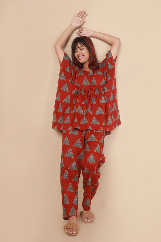 Woman wearing a red patterned outfit against a beige background