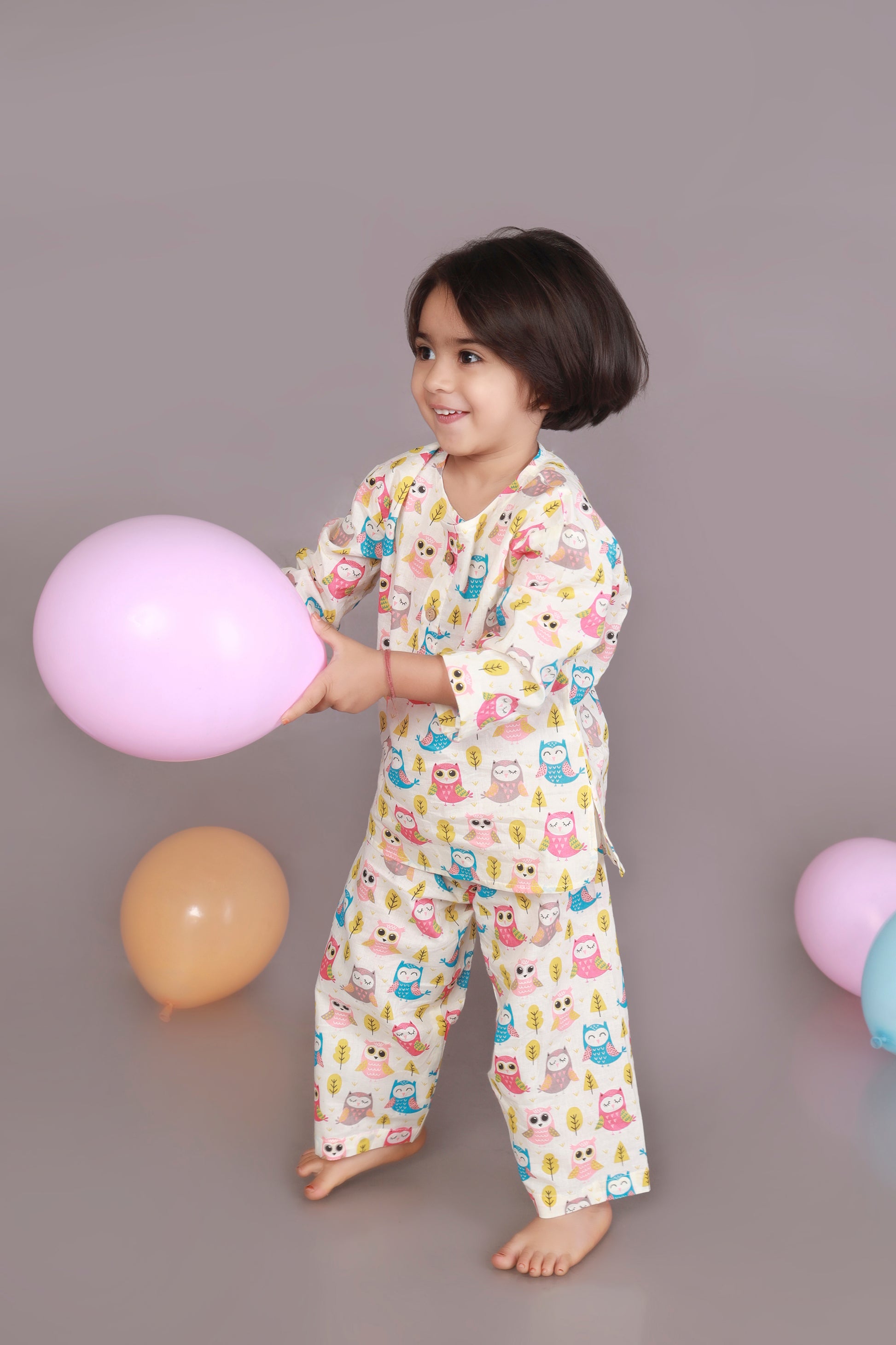 Child wearing a colorful owl patterned kurta pajama set 