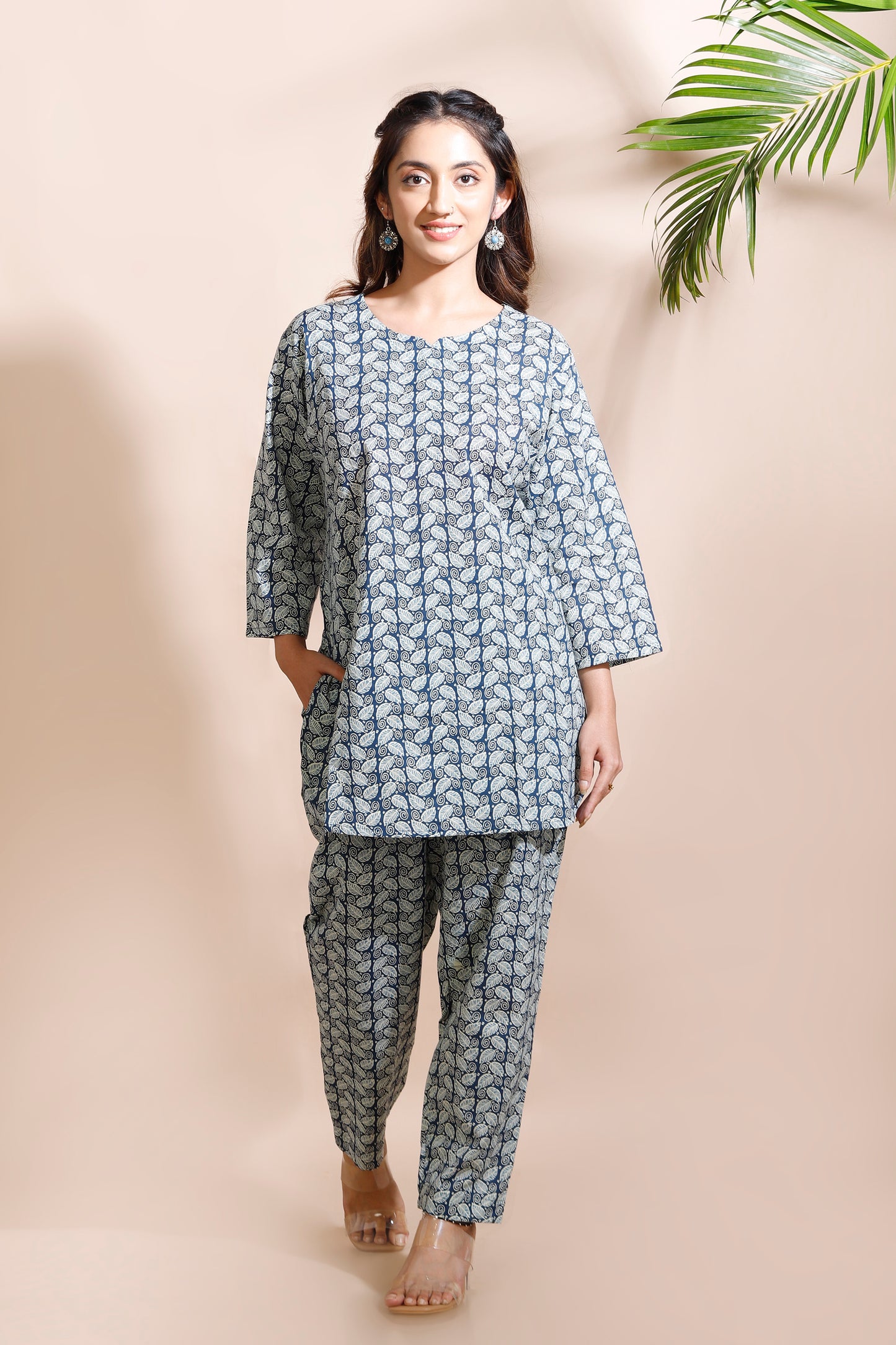 Woman wearing a blue floral kurta with matching pants against a beige background