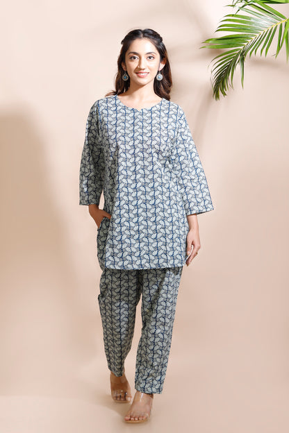 Woman wearing a blue floral kurta with matching pants against a beige background