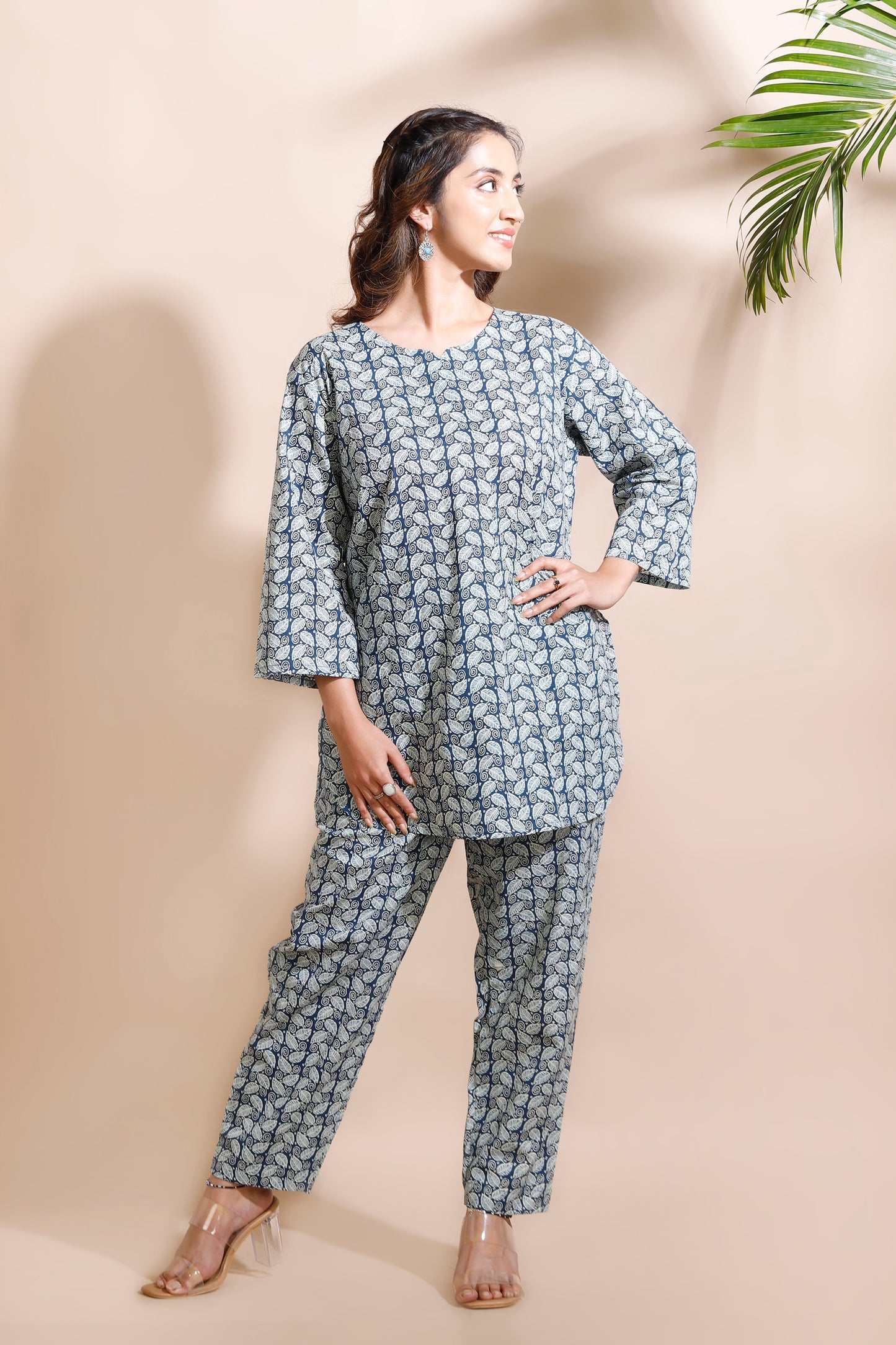 Woman wearing a blue floral outfit against a beige background