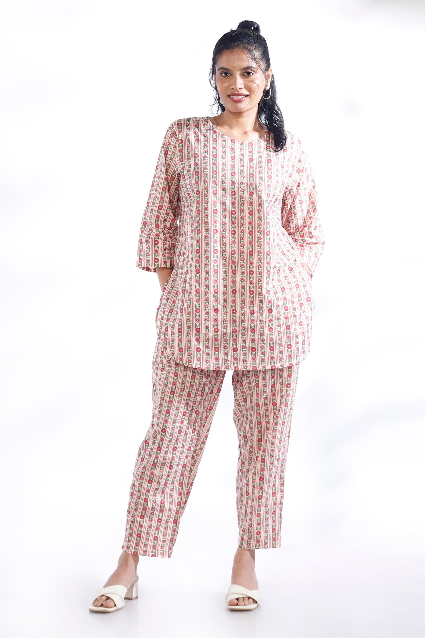 Woman wearing a matching set of kurta and pants with a white background