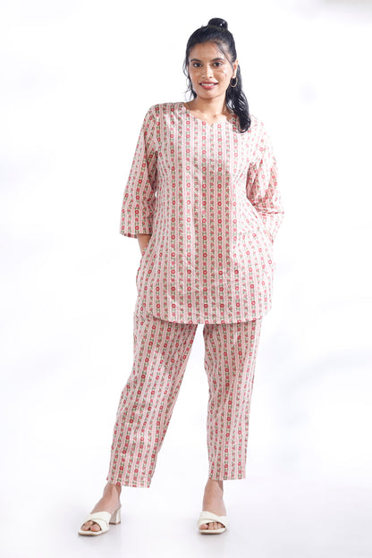 Woman wearing a matching set of kurta and pants with a white background