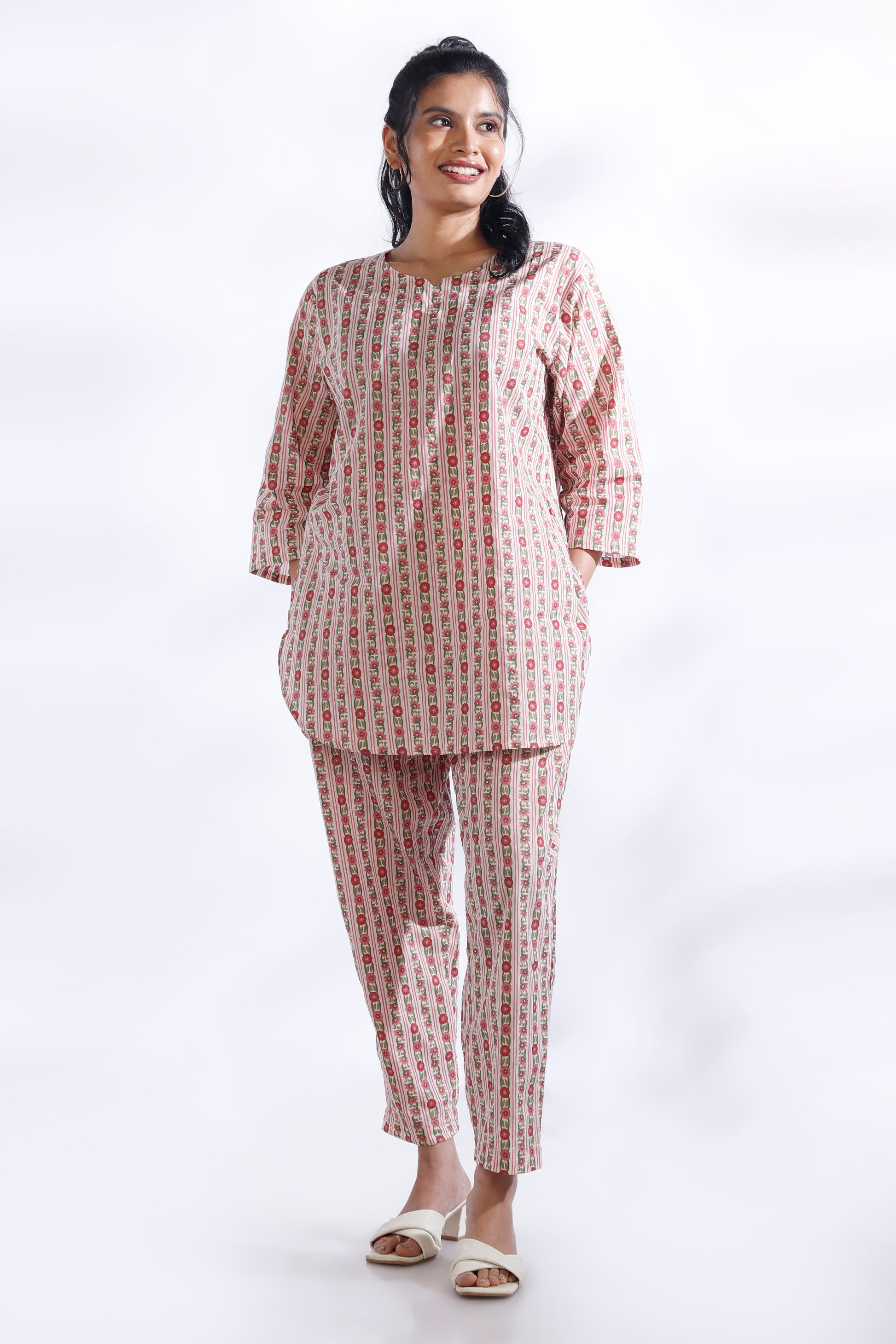 Woman wearing a matching set of top and pants with a white background