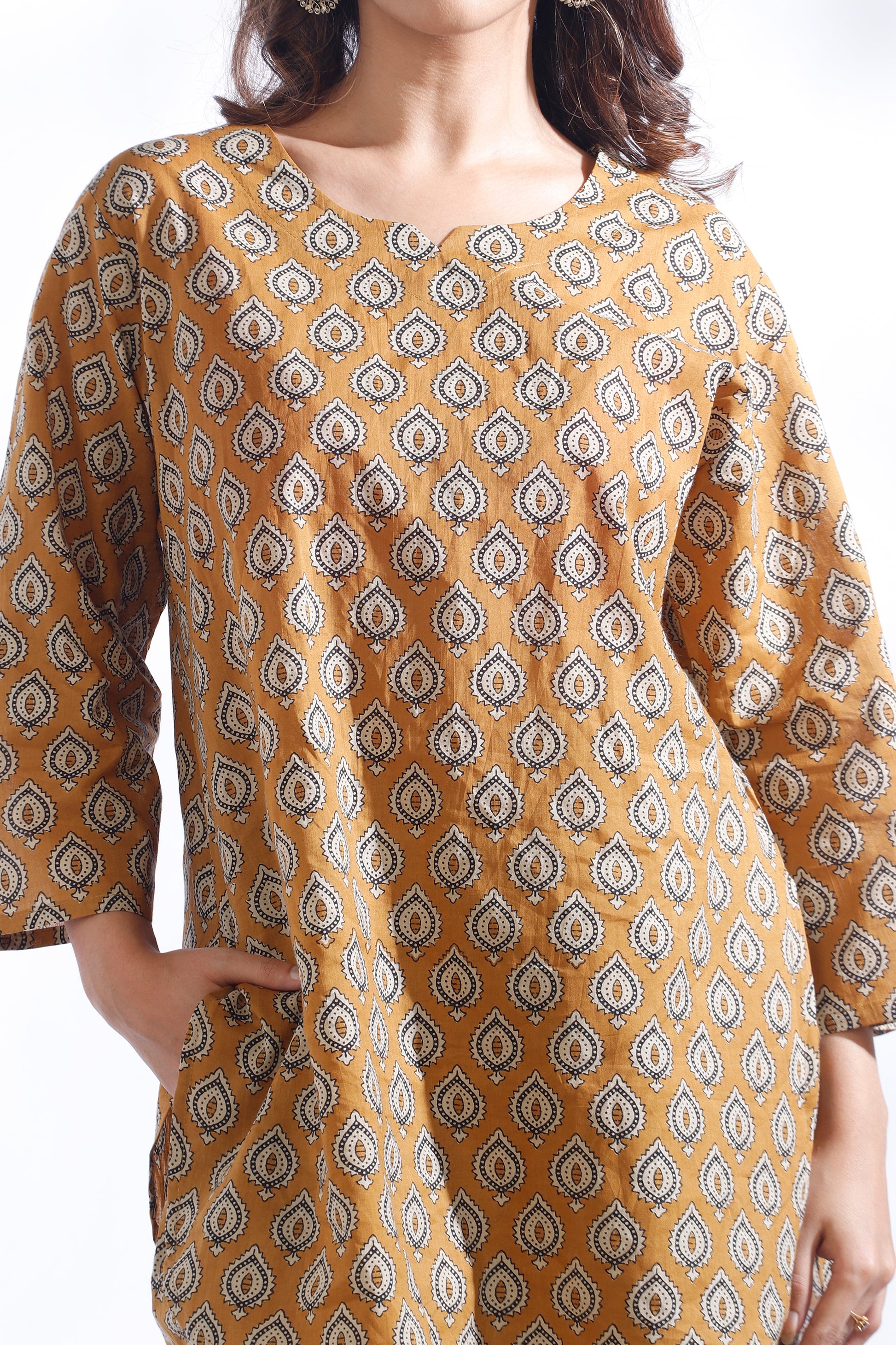 Woman wearing a mustard yellow kurta with a geometric pattern on a white background