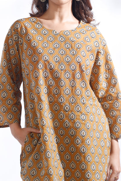 Woman wearing a mustard yellow kurta with a geometric pattern on a white background