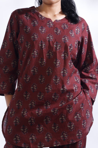 Maroon patterned kurta worn by a person on a white background