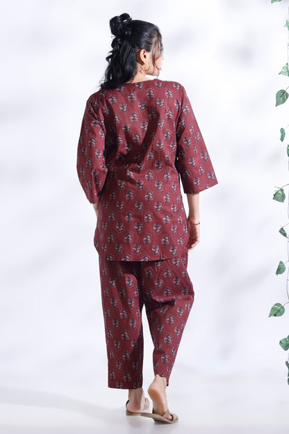 Person wearing a maroon patterned outfit on a white background