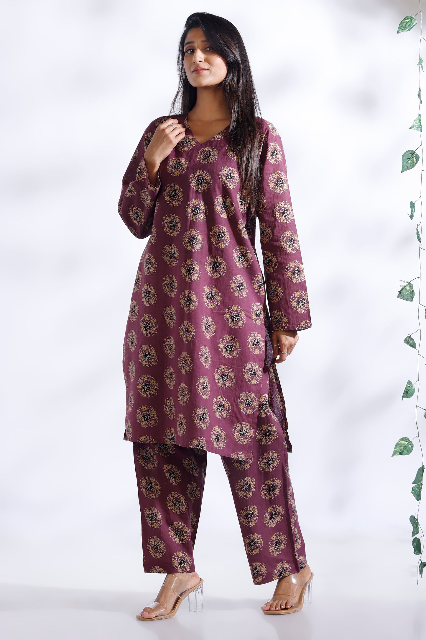 Woman wearing a purple floral kurta with pants on a white background
