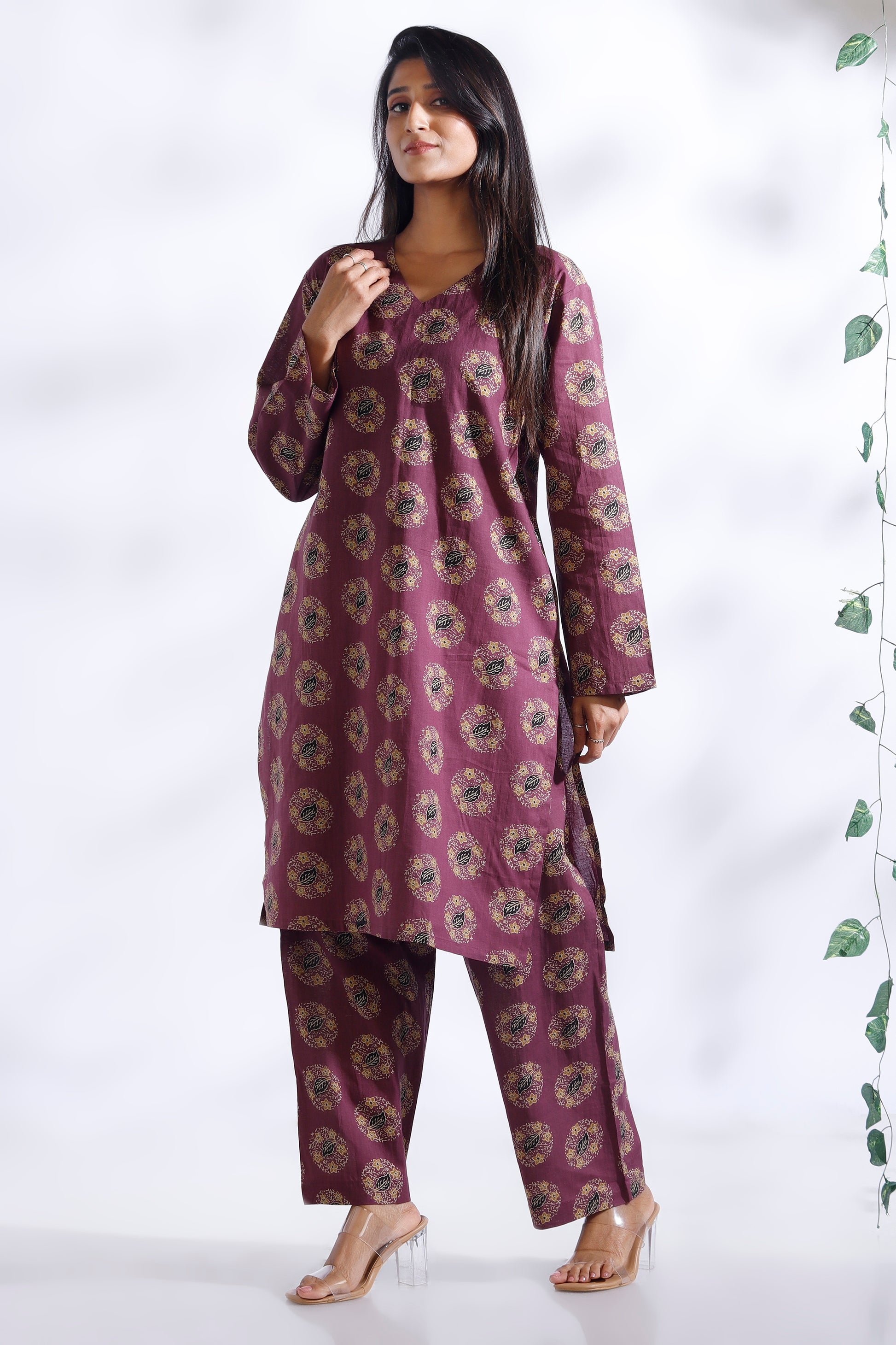 Woman wearing a purple floral kurta with pants on a white background