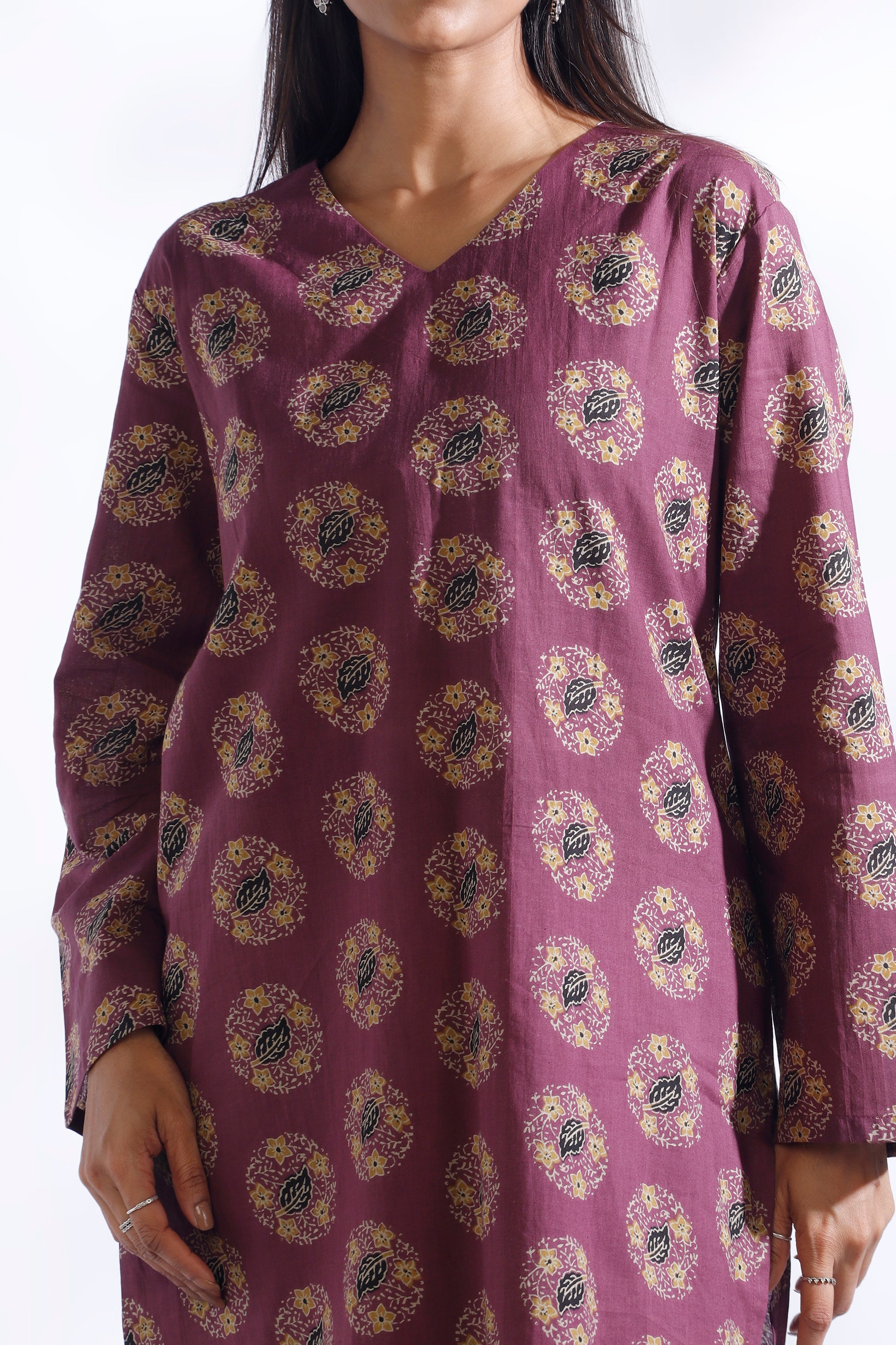 Purple patterned dress worn by a model on a white background