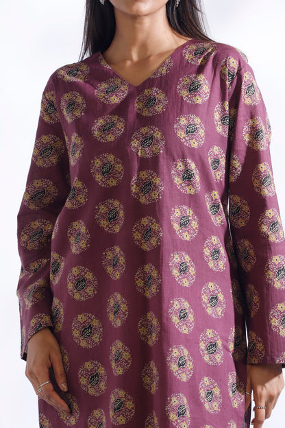 Purple patterned dress worn by a model on a white background