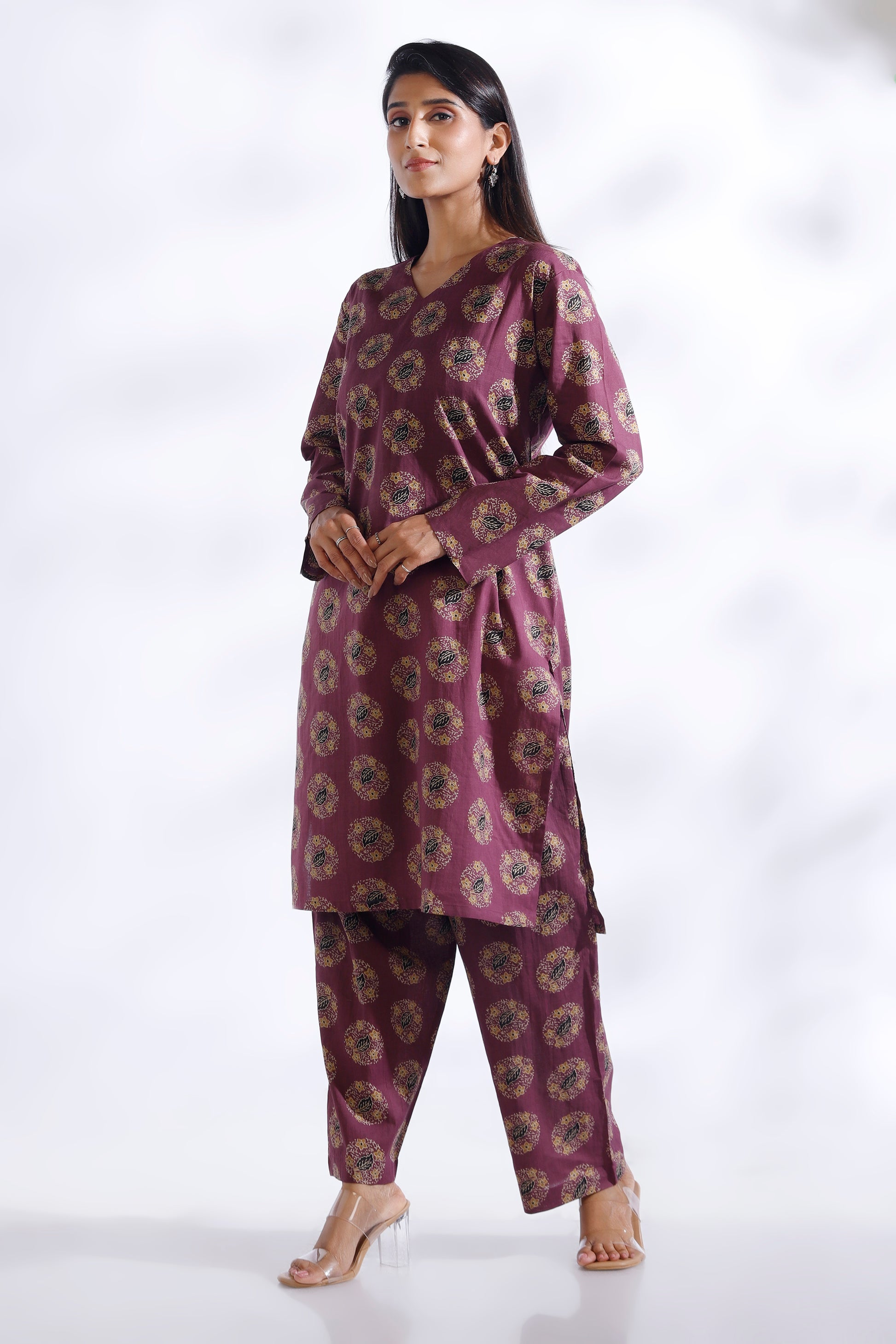 Woman wearing a purple patterned outfit on a white background