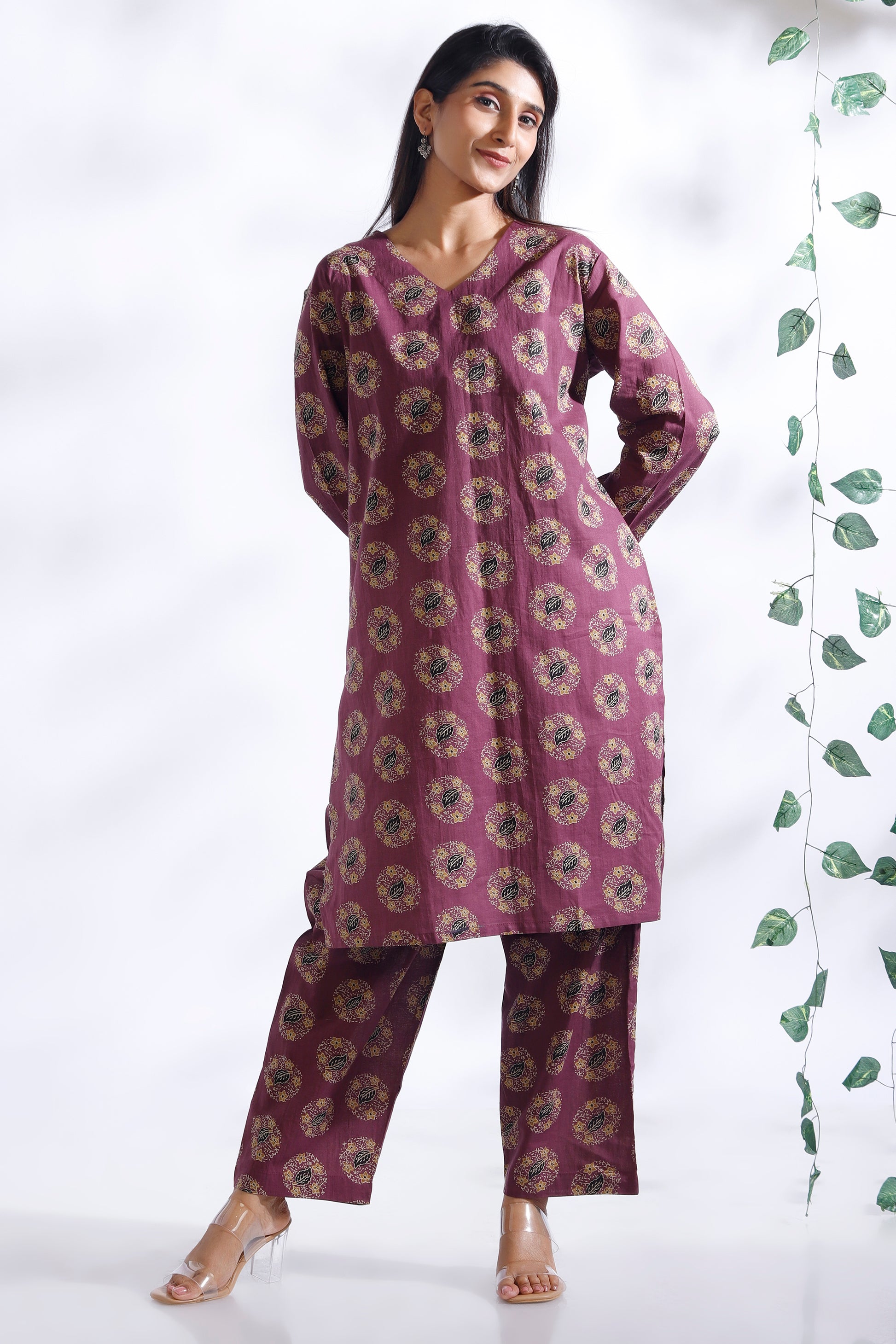 Woman wearing a purple floral outfit with a white background