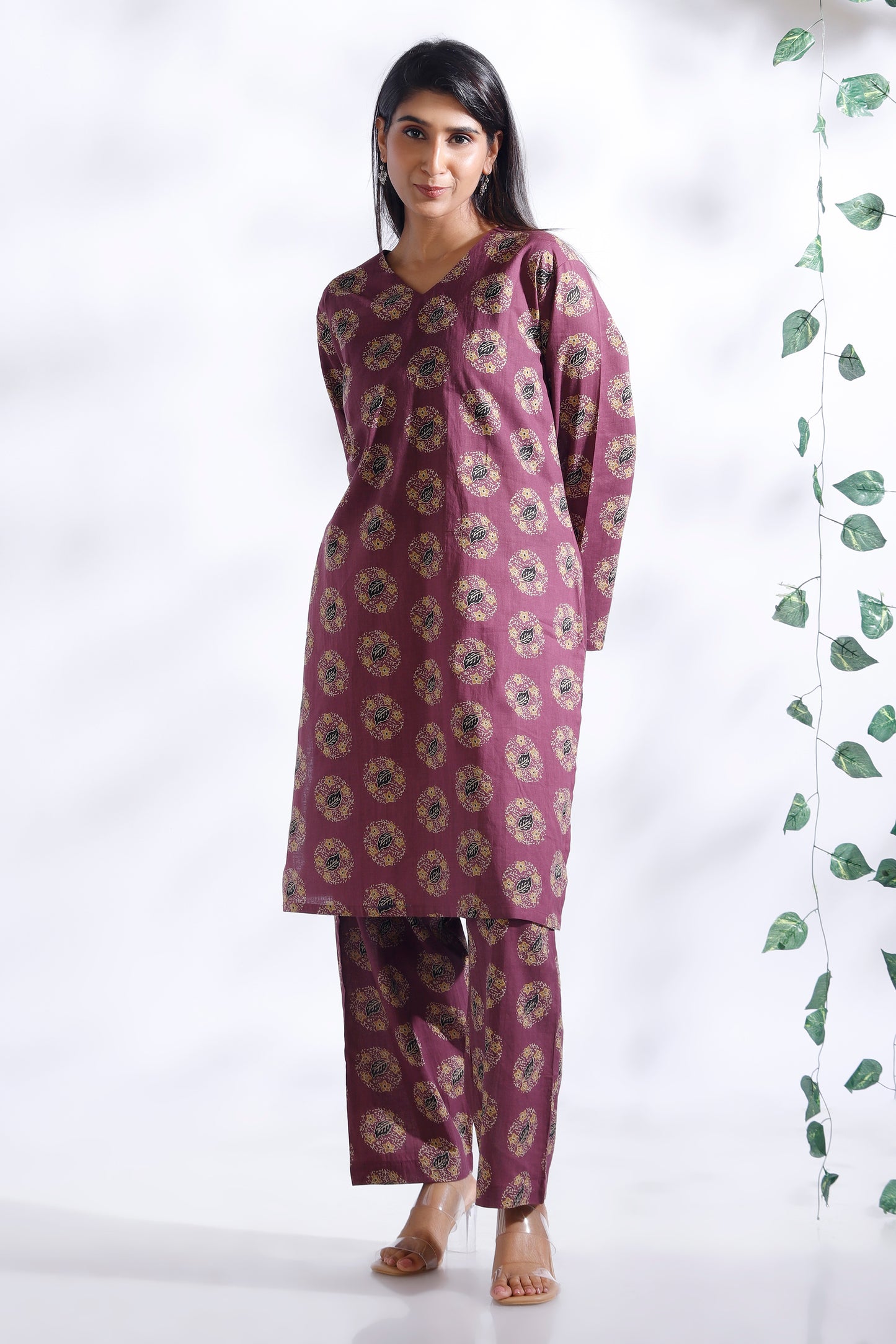 Woman wearing a purple floral kurta with matching pants against a white background