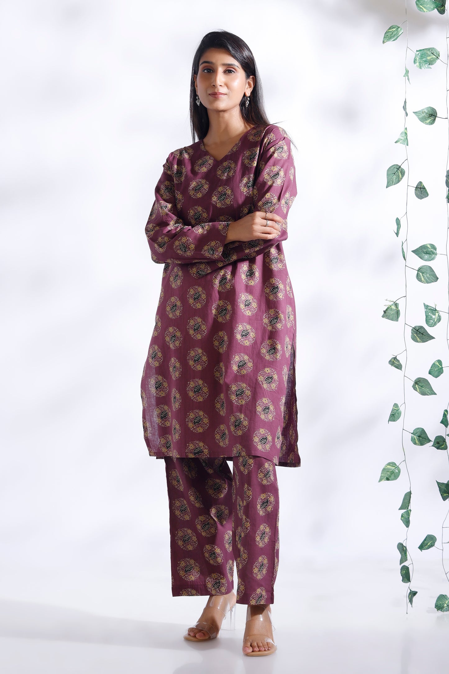 Woman wearing a purple floral kurta with pants against a white background