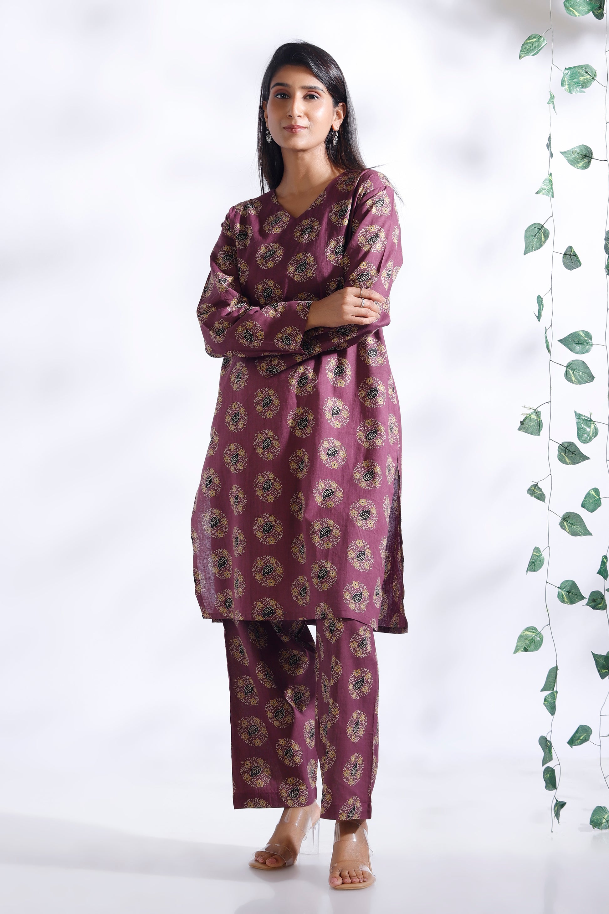 Woman wearing a purple floral kurta with pants against a white background