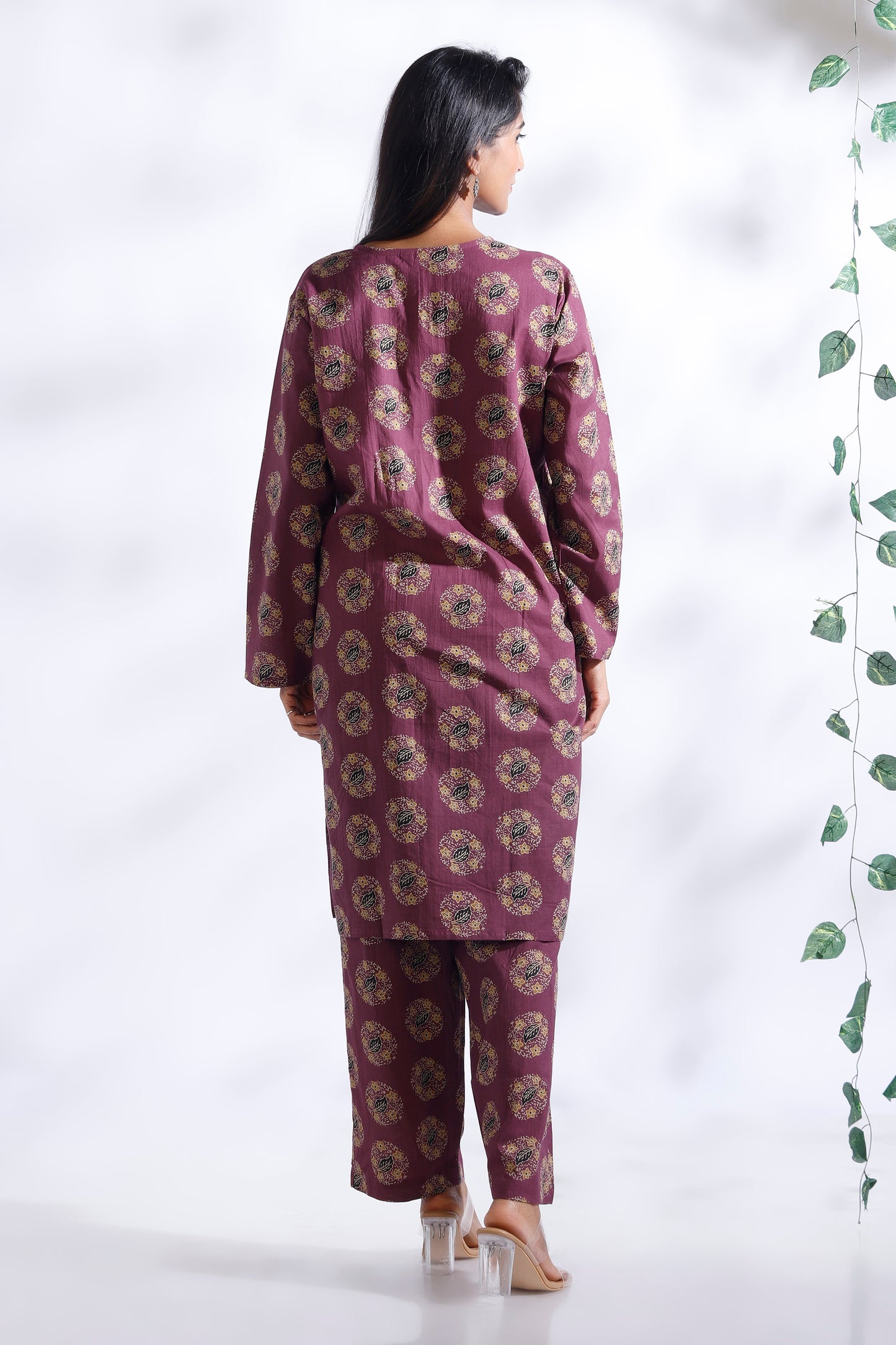 Woman wearing a purple floral outfit against a white background
