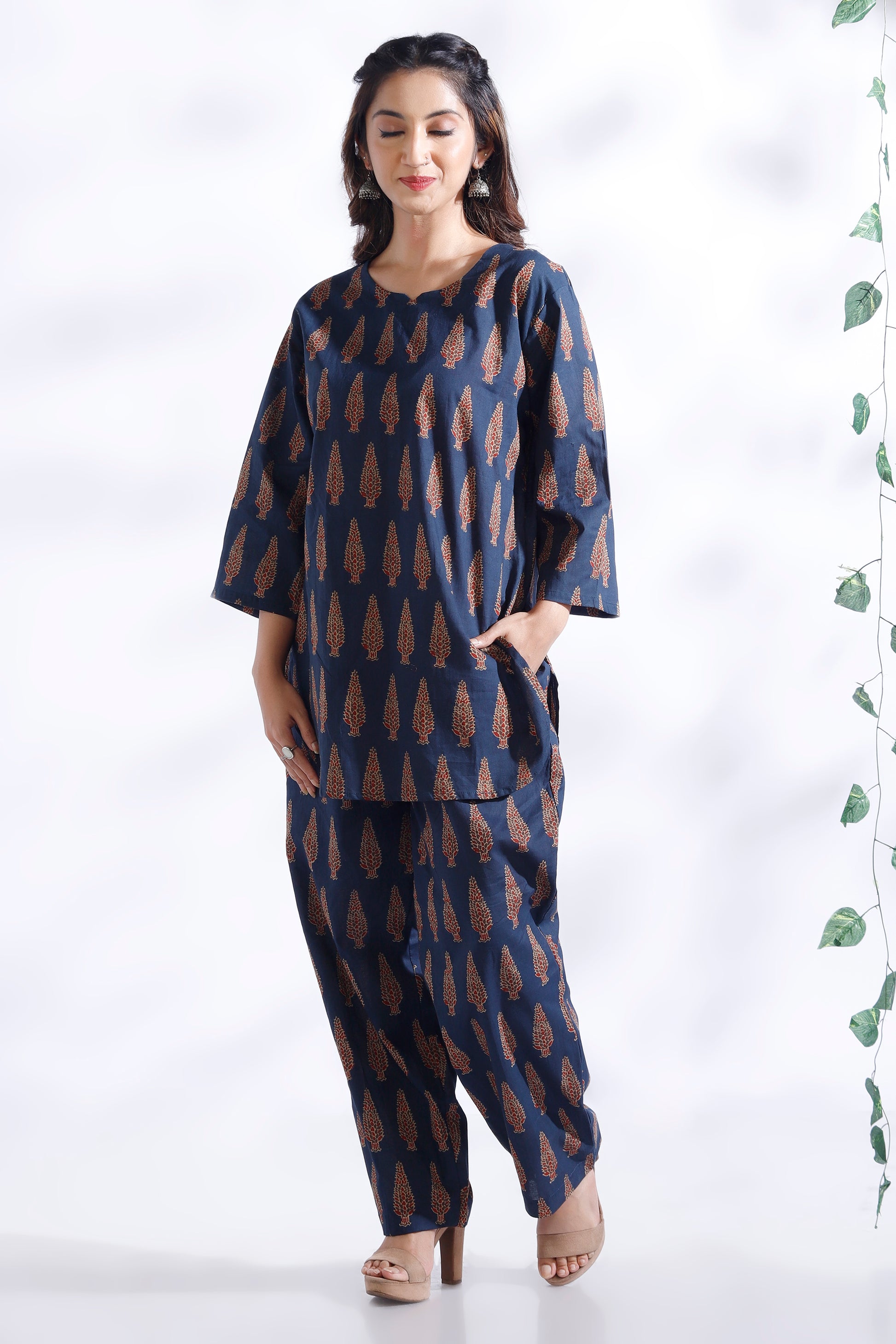 Woman wearing a blue and brown patterned outfit on a white background