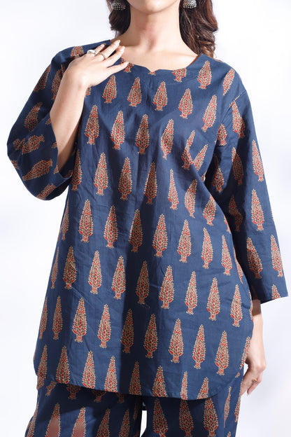 Navy blue top with brown leaf pattern worn by a model on a white background
