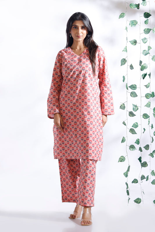 Woman wearing a pink floral kurta with matching pants against a white background