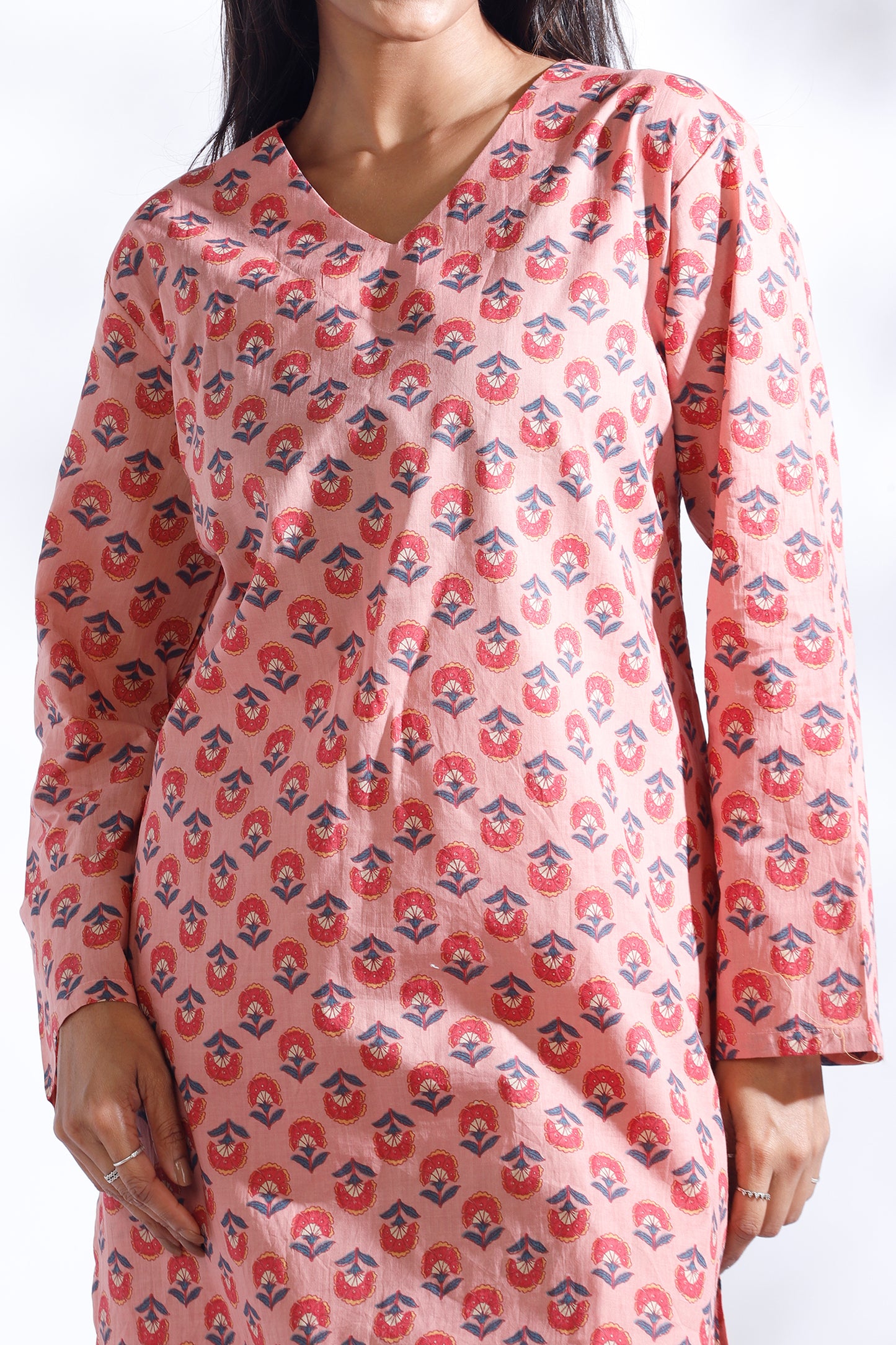 Woman wearing a pink patterned dress against a white background