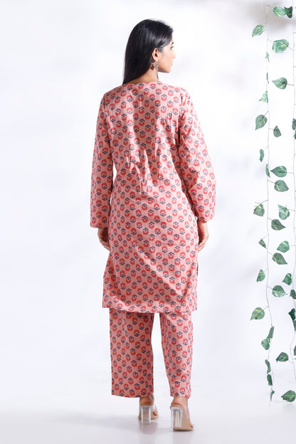 Woman wearing a pink floral kurta with pants on a white background
