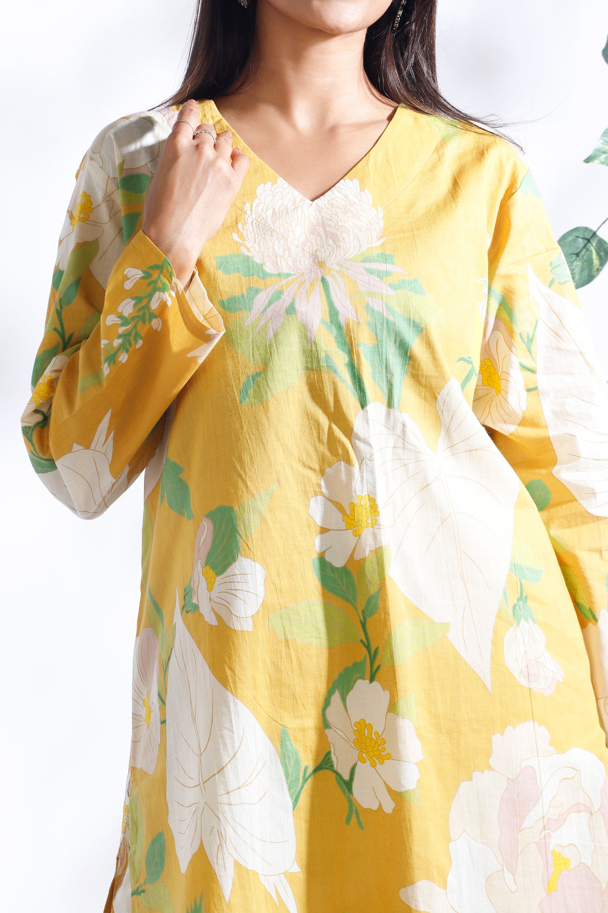 Yellow floral dress worn by a person on a white background