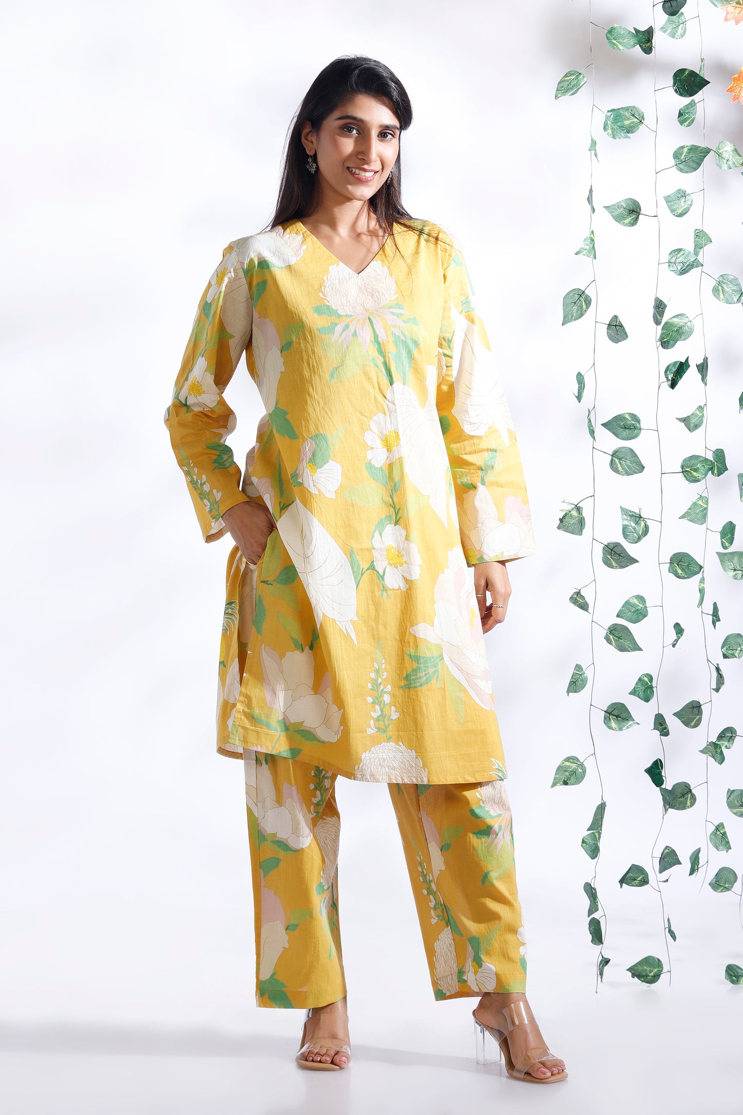 Woman wearing a yellow floral outfit with a white background