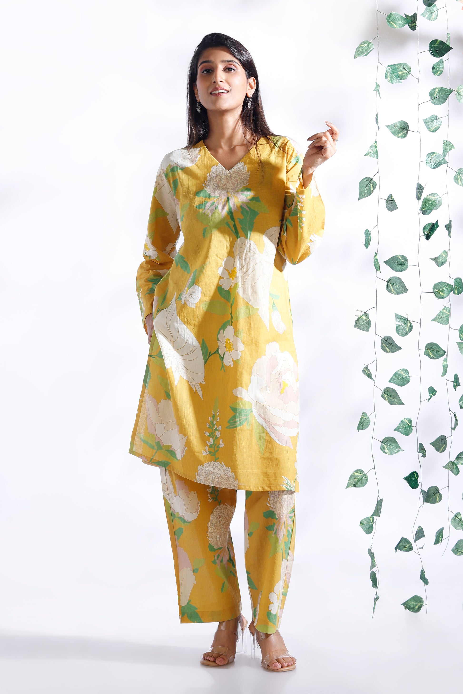 Woman wearing a yellow floral outfit with a white background