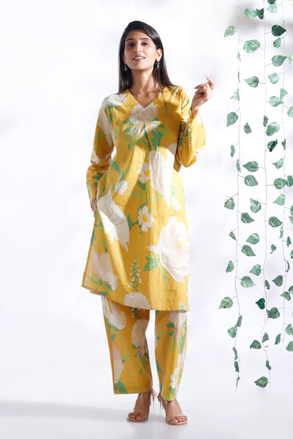 Woman wearing a yellow floral outfit with a white background