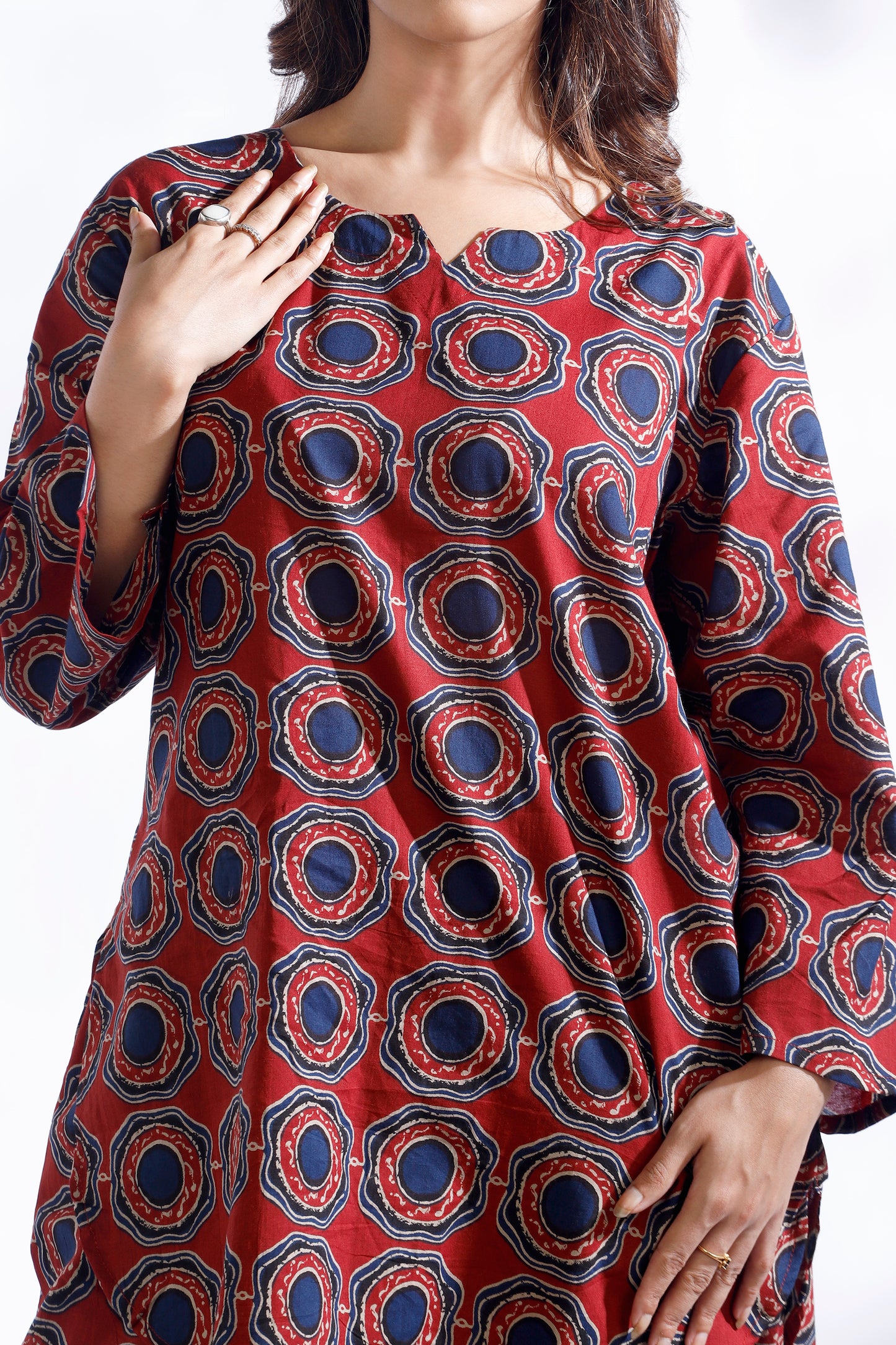 Red patterned dress worn by a person on a white background