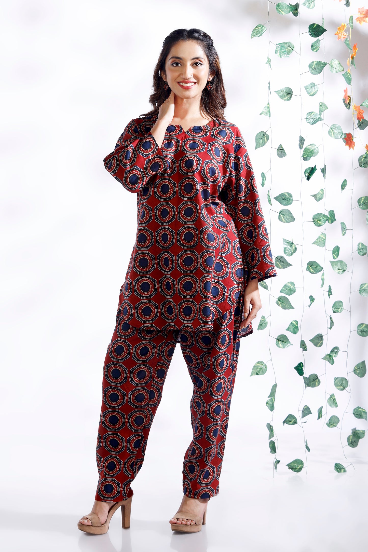 Woman wearing a red and blue patterned outfit with a white background