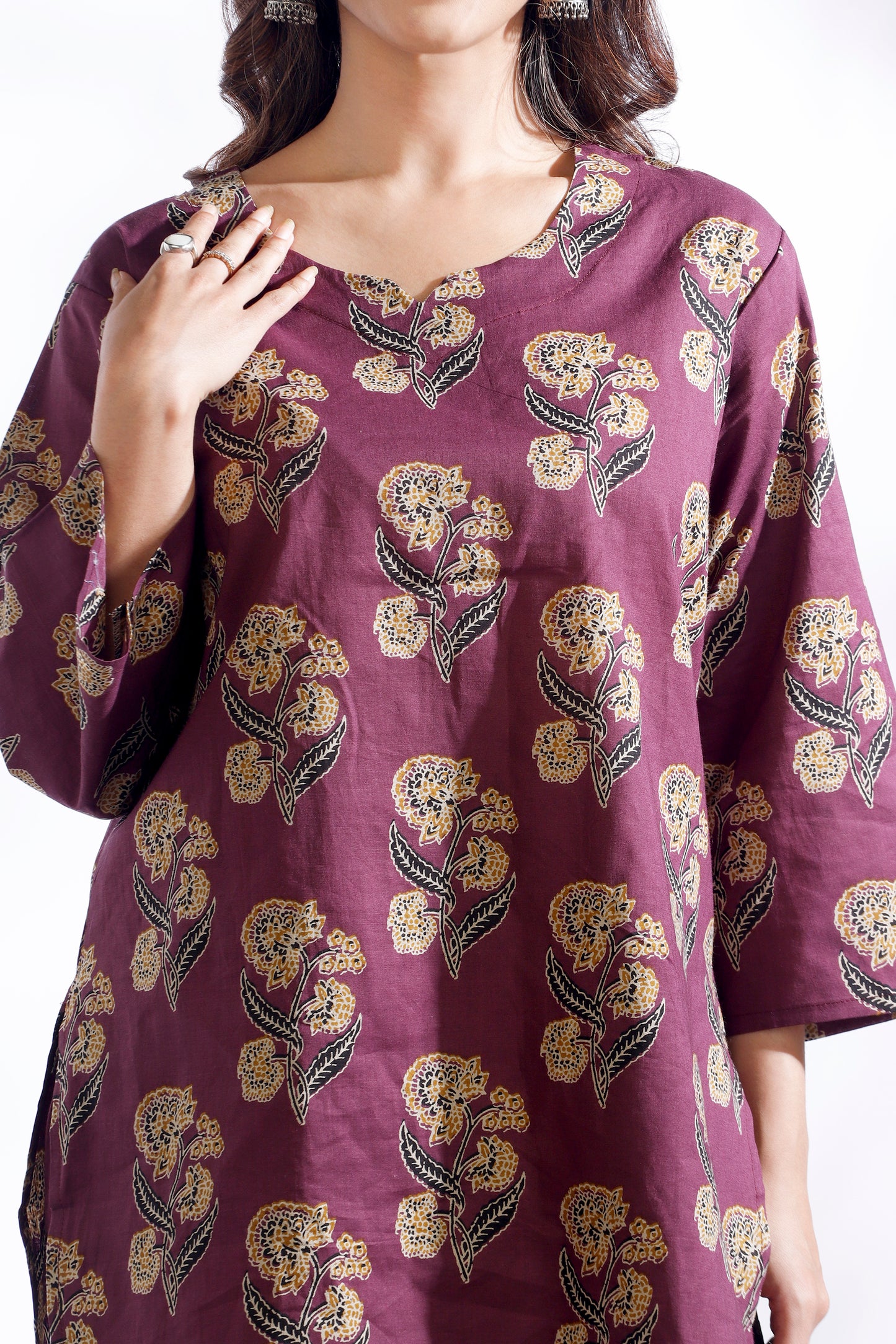 Purple dress with floral pattern worn by a model on a white background